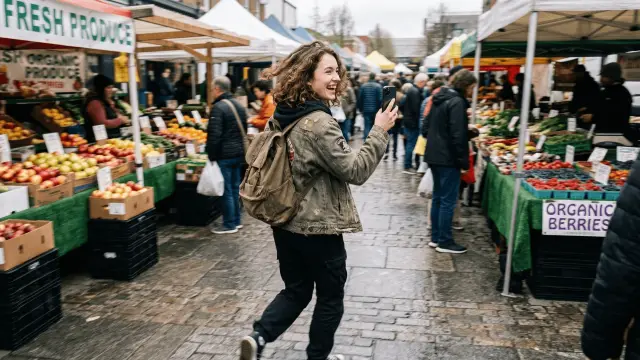 Blogger or affiliate creator walking through a busy market with phone in hand